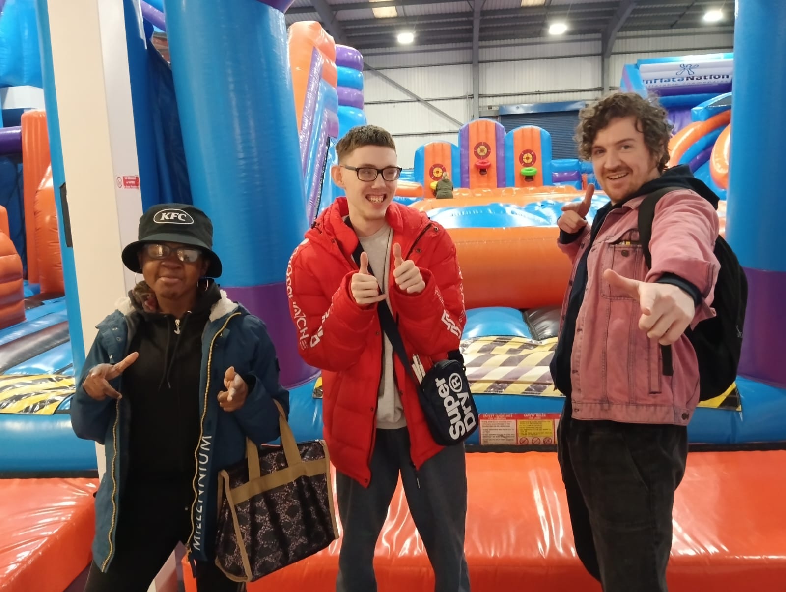 Young people and staff at an indoor inflatable park